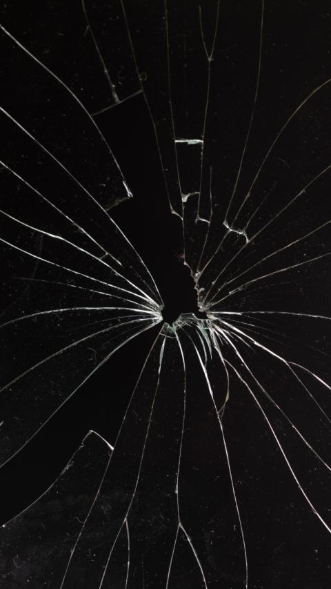 Shattered glass window against black wallpaper